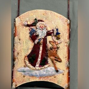 Adorable metal sled Santa decoration. Santa carries toys, a lantern and a friend